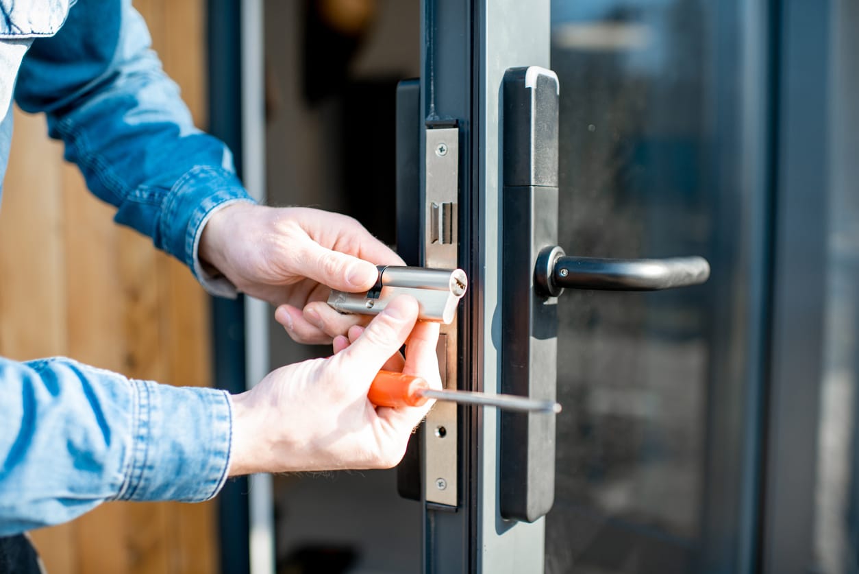 man fixing a commercial door lock.