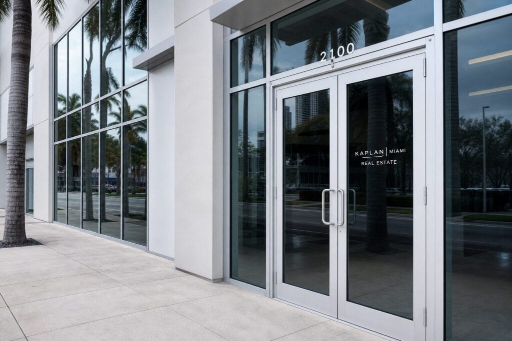 Commercial glass storefront door with aluminum frame on Miami office building sidewalk